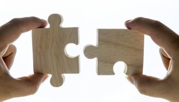 Macro shot of jigsaw puzzles teamwork concept